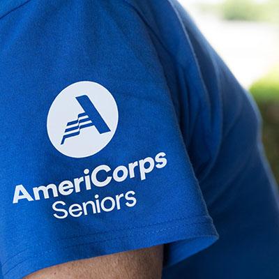 Close-up of the AmeriCorps Seniors logo on a blue T-shirt
