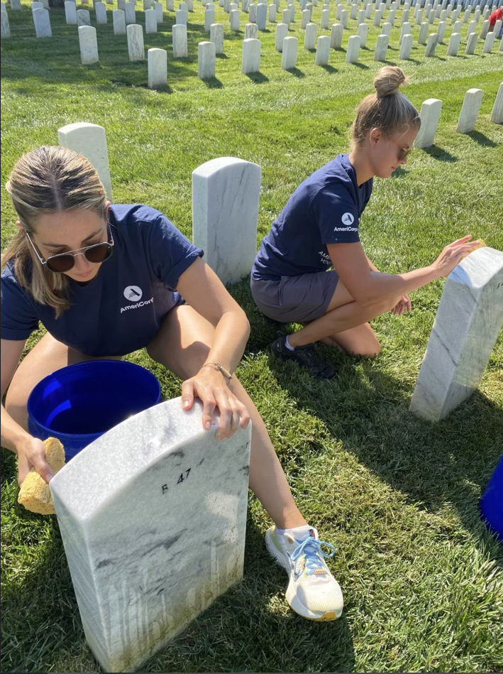 AmeriCorps leaders clean headstones at Alexandria National Cemetery. 