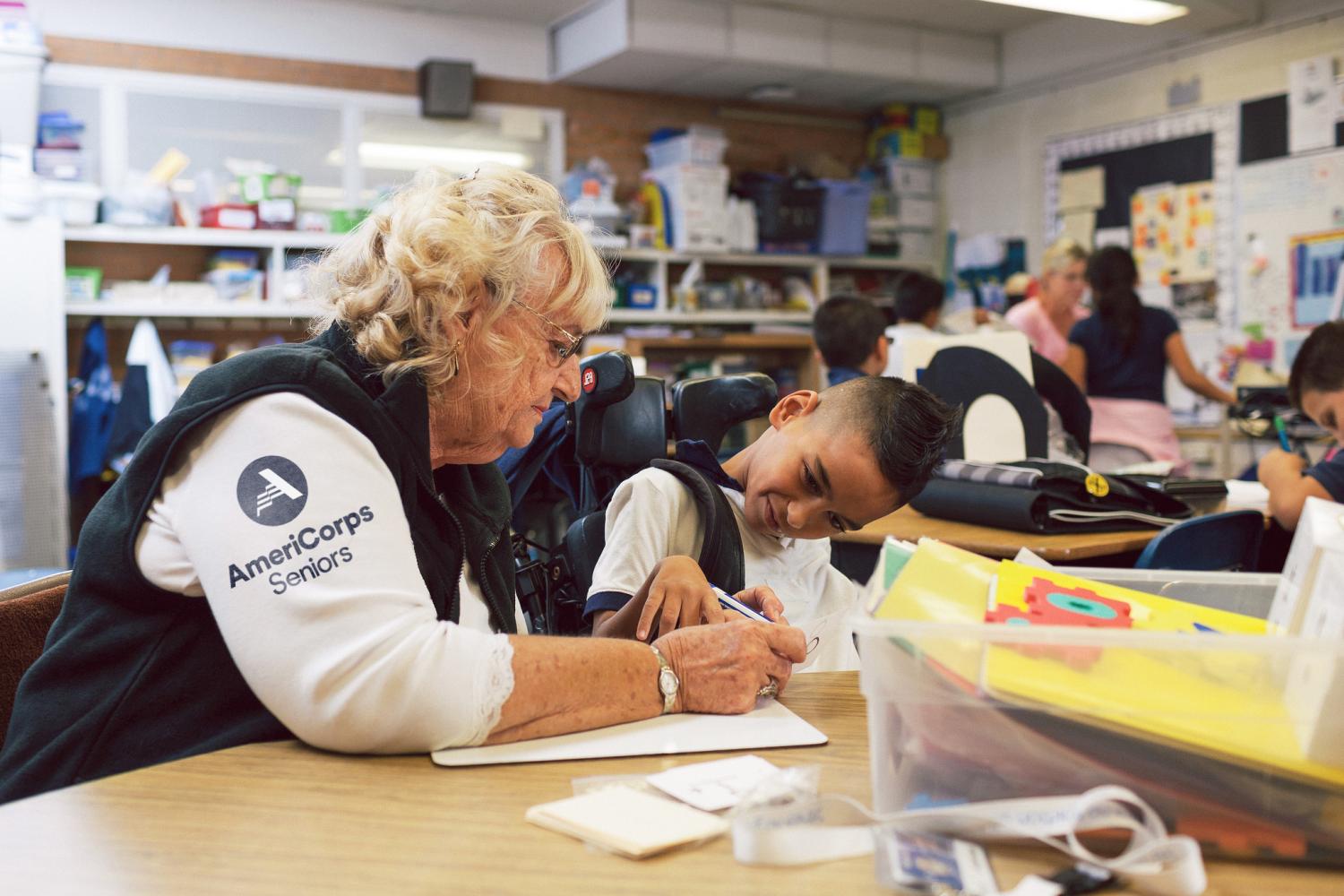 AmeriCorps Senior member helping a student with school work.
