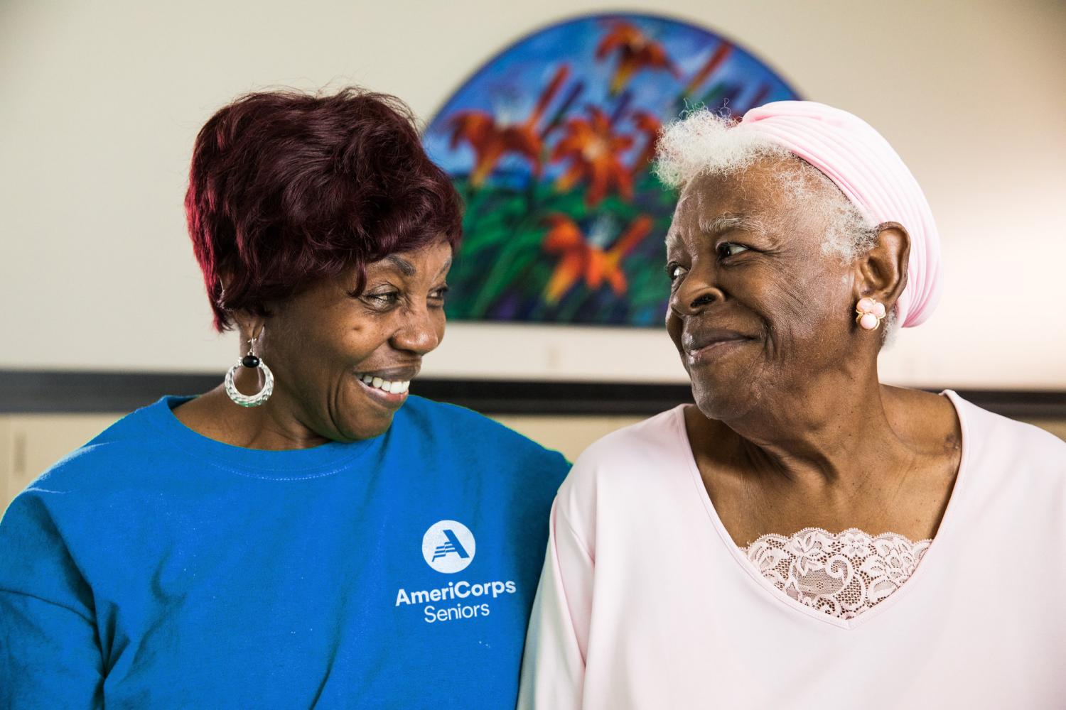 AmeriCorps Seniors volunteer with fellow senior, laughing at senior's house