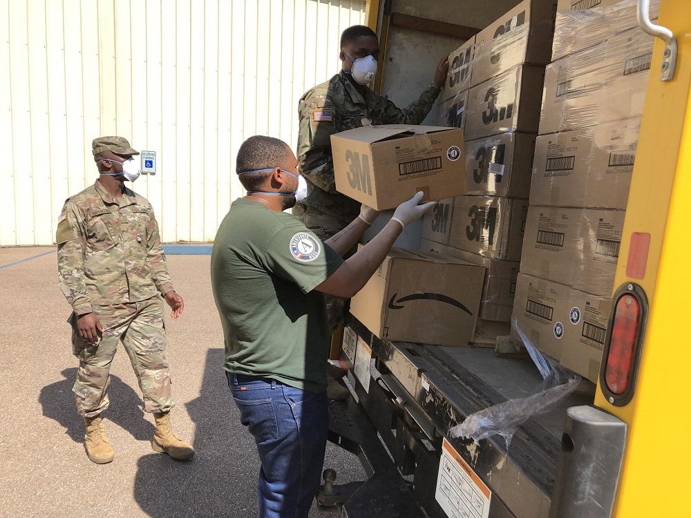 AmeriCorps member and army volunteers move surgical masks to donate